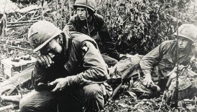 A group of soldiers are resting in the grass after receiving the Medal of Honor.