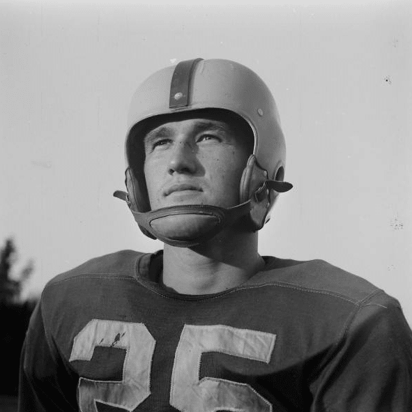 A black and white photo of a football player captures the essence of a manvotional moment on the field.