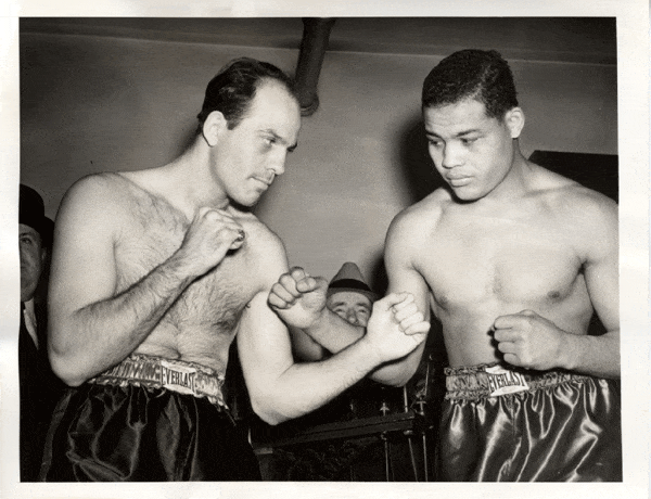 Two boxers standing in a black and white photo.