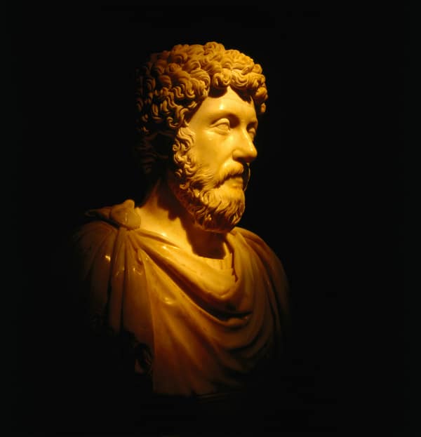 A bust of Marcus Aurelius in a dark room, evoking reflections.