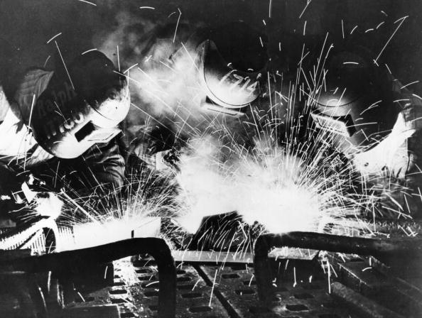 A black and white photo of a welder with sparks captures the essence of masculinity.