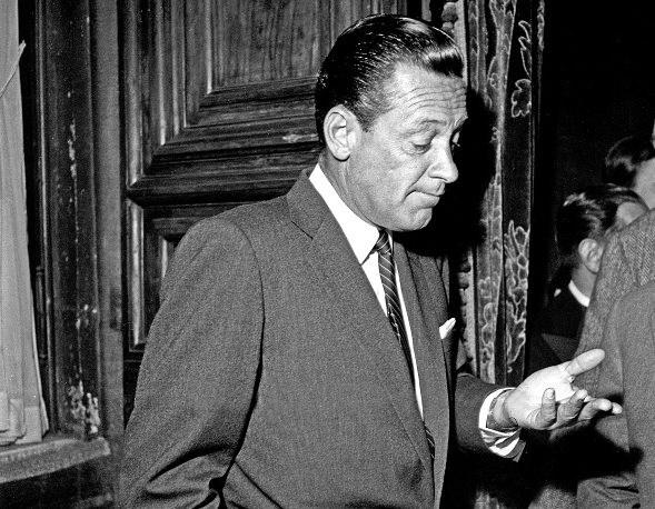 Two men in suits engaged in conversation.