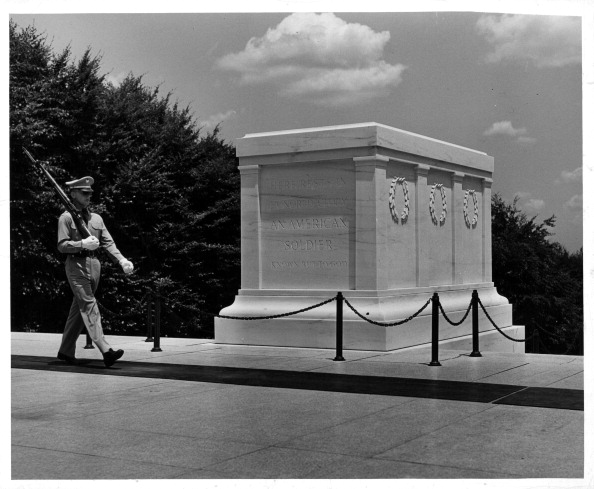 A soldier stands next to the inspiring tomb of the unknown soldier.