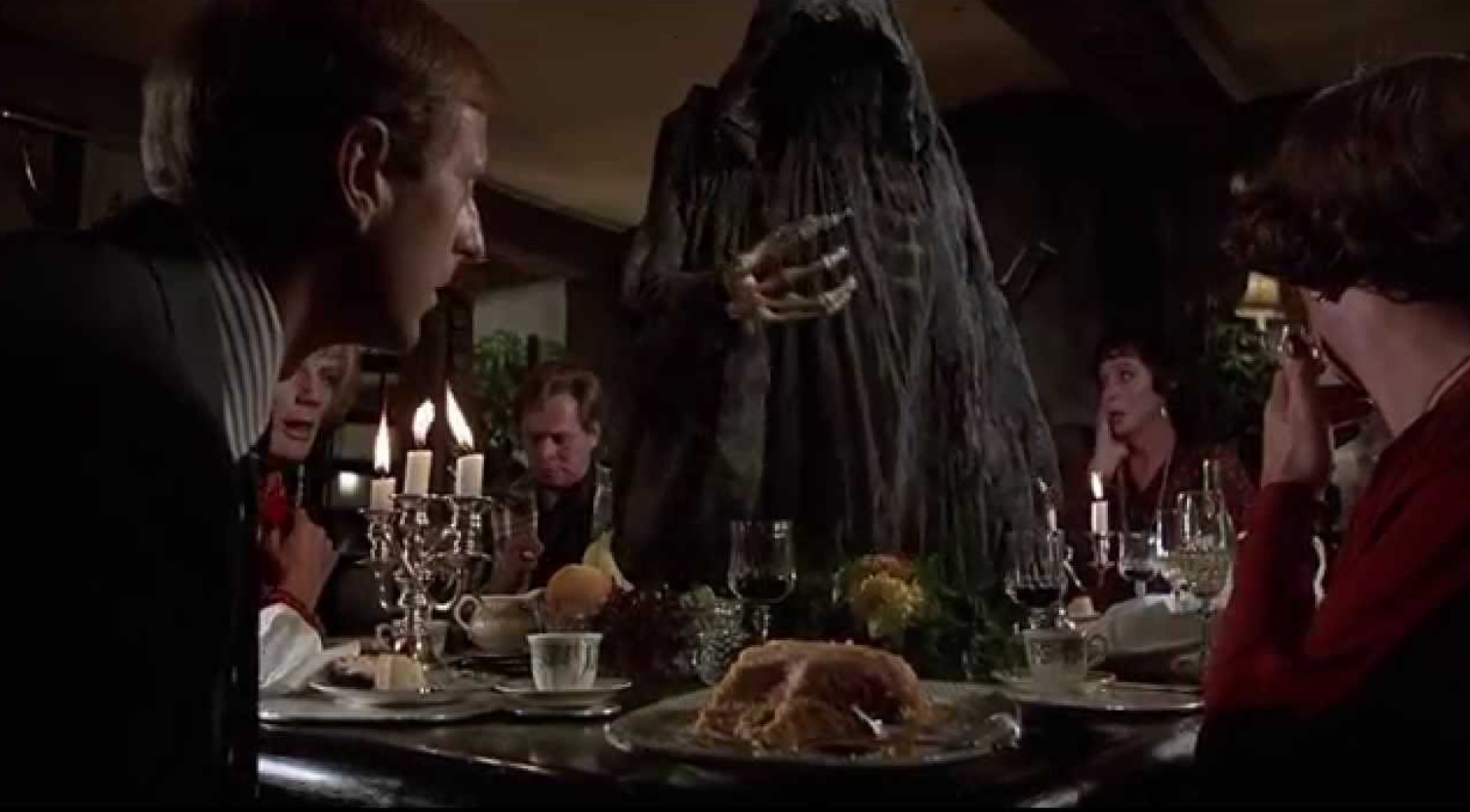 A group of people sitting around a table with a ghost during Death Over Dinner.