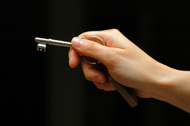 A person's hand holding a key, symbolizing personal agency.