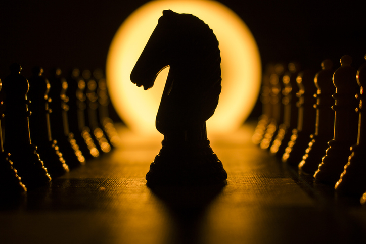 A silhouette of a horse on a chess board symbolizes strategic planning and calculated moves towards fulfillment.