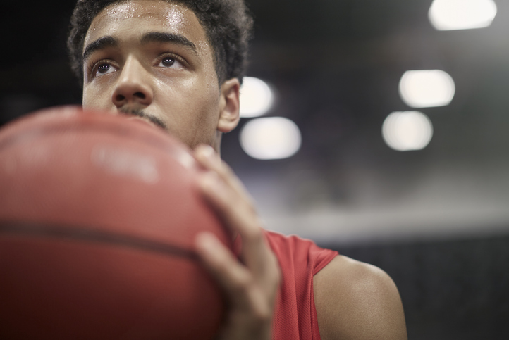 A basketball player performing, holding a ball in his hand.