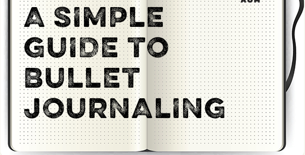 An open dotted Bullet Journal with the title "A Simple Guide to Bullet Journaling" written on the spread.