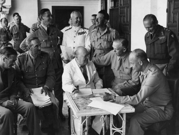 A group of military men sitting around a table, discussing wartime leaders.