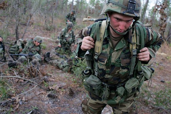 A soldier from army ranger school walking through the woods.
